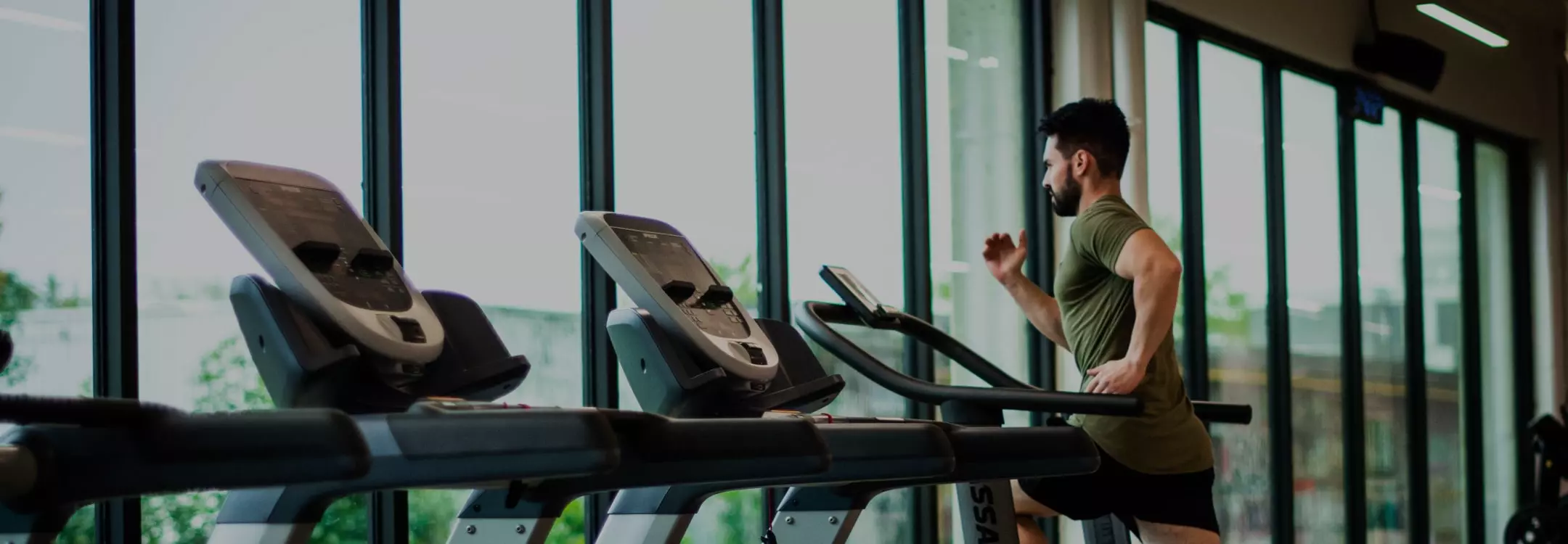Athletic male on treadmill while using Les Mills video streaming mobile app.